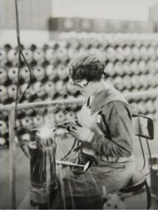 A female welder working on a Liberty engine at the Lincoln Motor Company during World War I, ca. 1917.