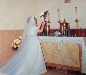 Judi at the altar of Our Lady placing flowers during the singing of Ave Maria.